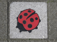 908189 Afbeelding van een tegel met de afbeelding van een lieveheersbeestje ('als positief signaal tegen pesten en ...